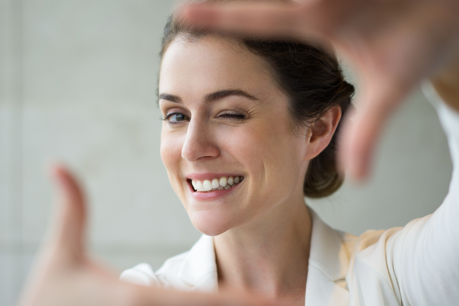 Woman with a healthy, aligned smile framing her face with her hands